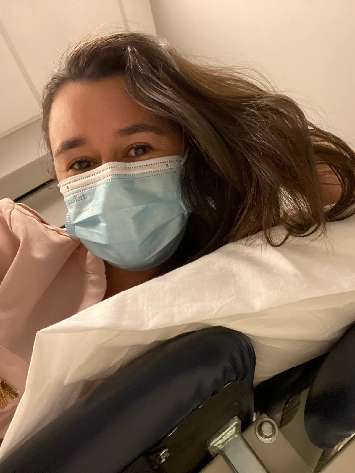 Stephanie Moss as a patient, wearing a mask in a treatment chair.